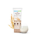 Mamaearth Rice Dewy Bright Face Wash with rice grains and a glass of water on a white background