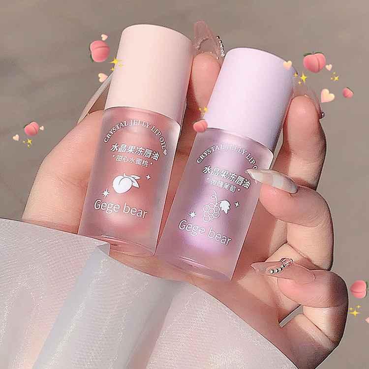Two small bottles of 'Gege bear' product held by a hand against a neutral background.