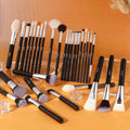 Set of makeup brushes with black handles and silver ferrules on an orange background
