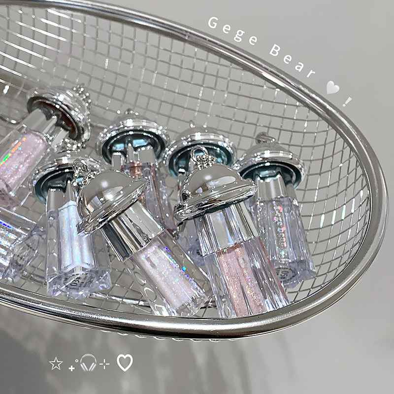 Clear and silver glittery cylindrical Eyeshadow Palette on a reflective surface with 'Gege Bear' branding.