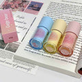 Four lip glosses in different colors on an open book
