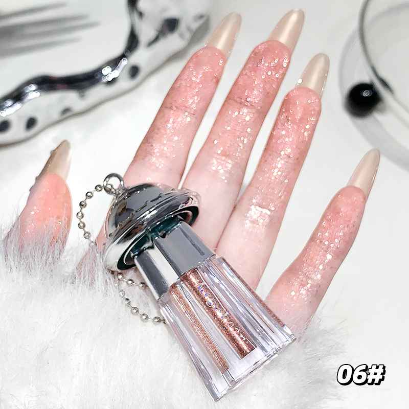 Eyeshadow Palette with a keychain held by a hand with glittery nails on a white background