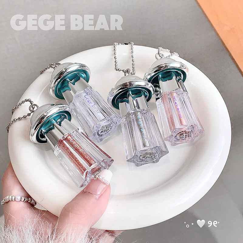 Clear bottle necklaces with colorful caps on a white plate, held by a hand.