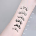 Set of false eyelashes on a person's arm with labeled sizes against a gray background