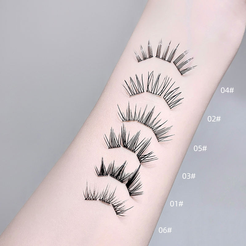 Set of false eyelashes on a person's arm with labeled sizes against a gray background
