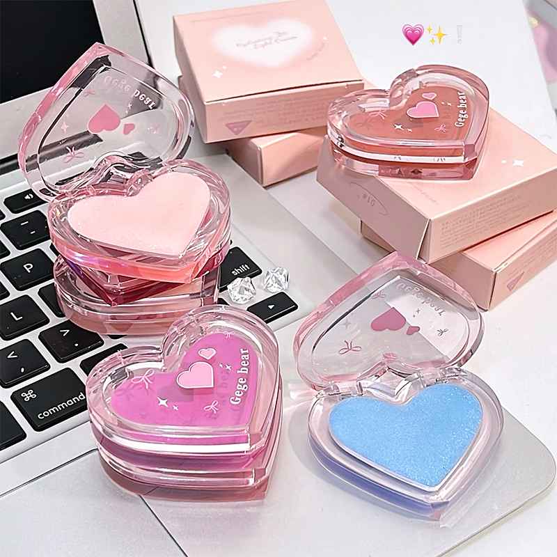 Heart-shaped blush with pink and blue powders on a laptop keyboard.