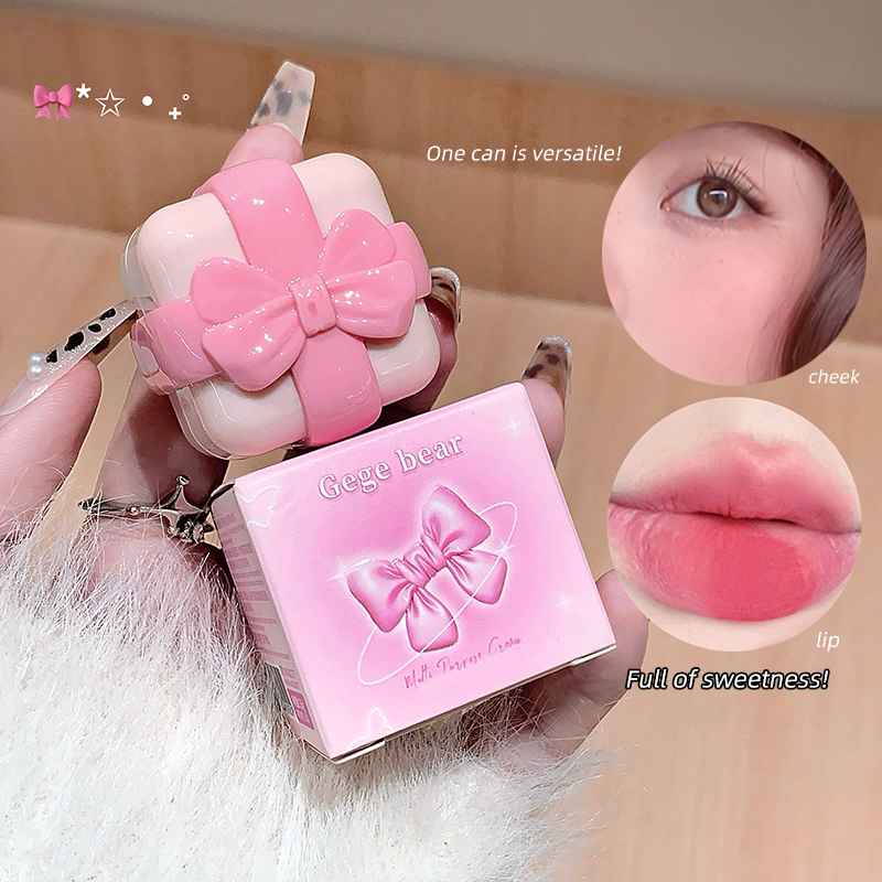 Pink cosmetic case with bow design held by a hand, close-up of face and lips.