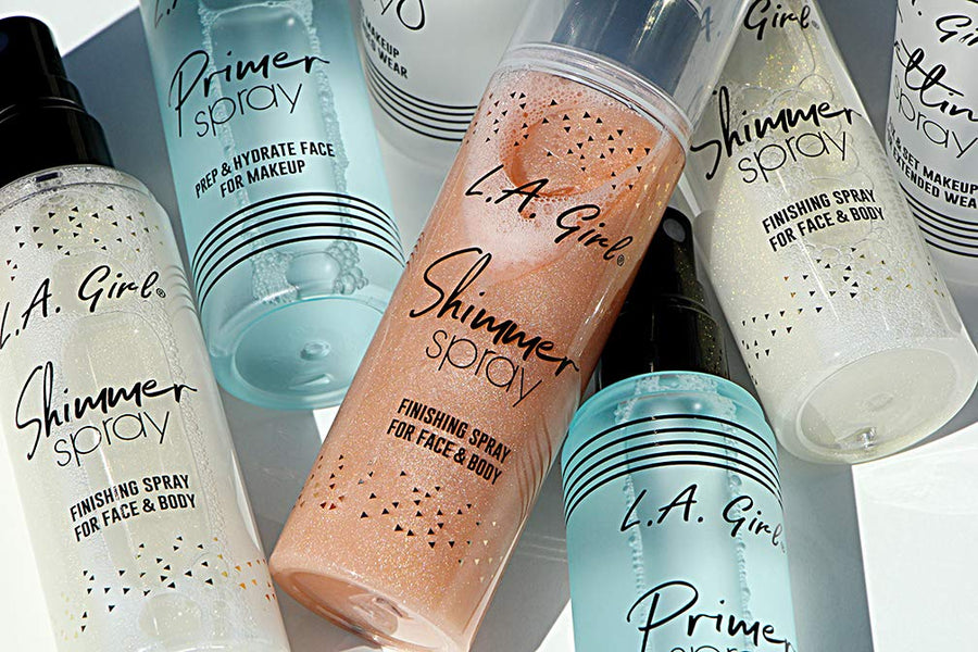 Collection of L.A. Girl makeup spray bottles on a light background