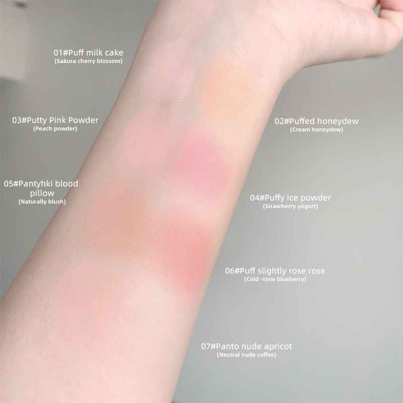 Color swatches of blush on a person's arm with labeled makeup shades.