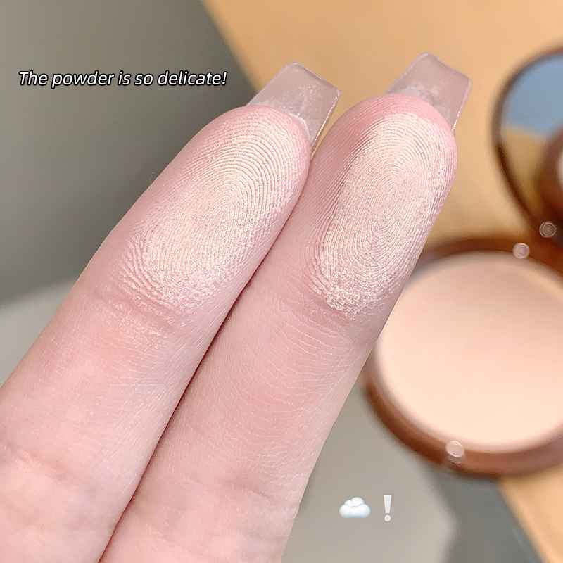Close-up of fingers with light-colored powder applied, with a compact powder case in the background.