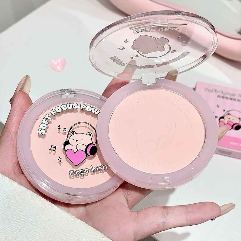 Compact with a cartoon bear design held in a hand.