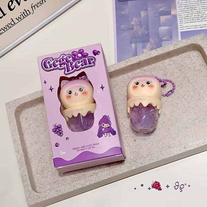 Clear lip oil in a sleek tube shown with a glossy applicator, reflecting a soft, luminous shine. The product appears lightweight and moisturizing, suggesting smooth, hydrated lips with a natural, non-sticky finish.