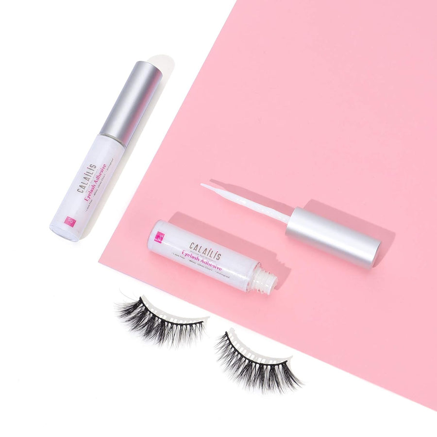 Eyelash adhesive and applicators on a pink background