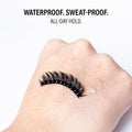 False eyelash on a hand with text 'Waterproof. Sweat-proof. All-day hold.'