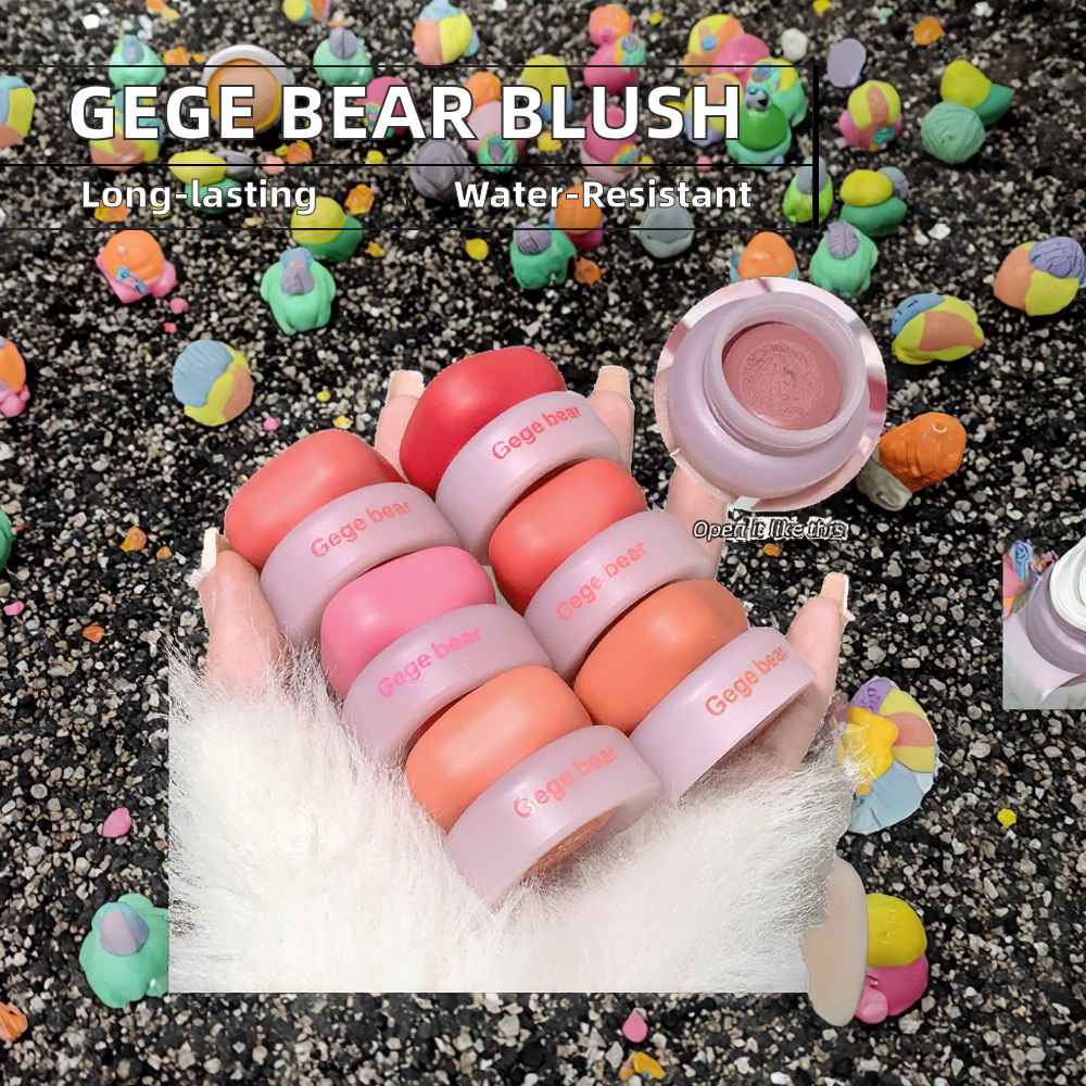 GEGE BEAR blush with packaging on a textured surface with colorful blurred items around.