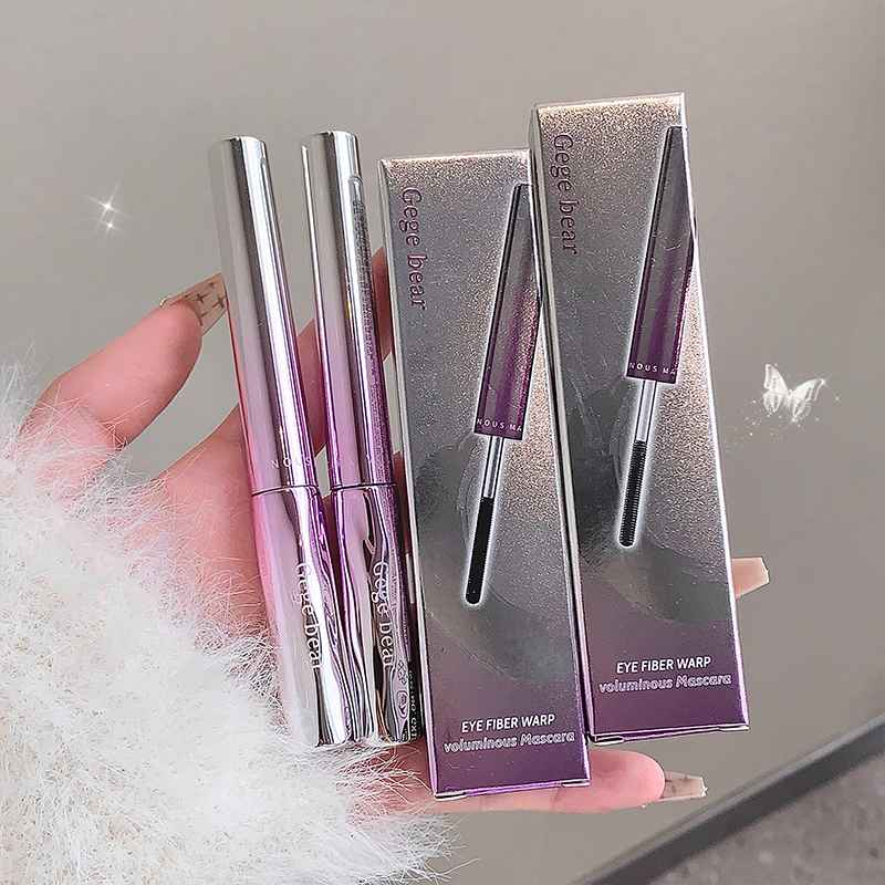 Gee Bear mascara with packaging held by a hand against a neutral background