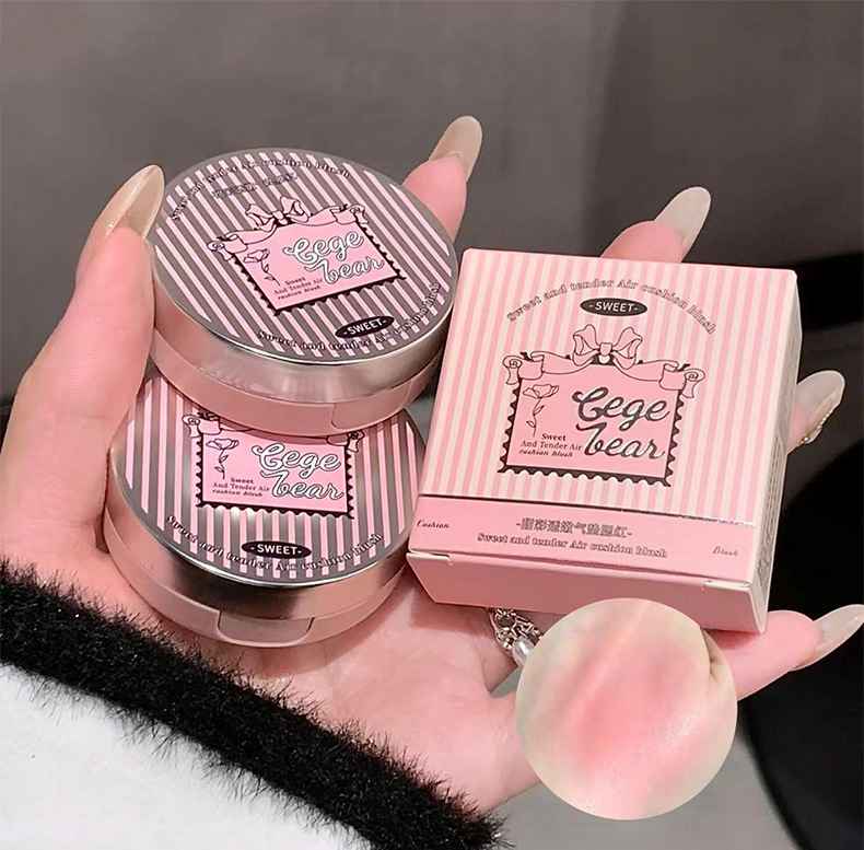 Pink makeup product with packaging held by a hand against a neutral background