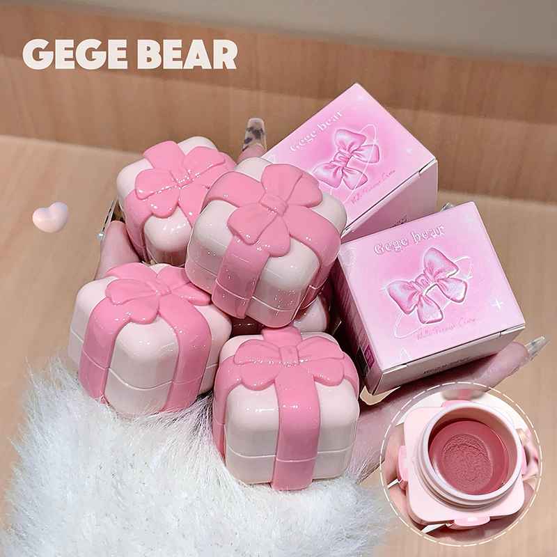 Pink and white cosmetic cases with bow design, branded 'GEGE BEAR', on a soft surface.