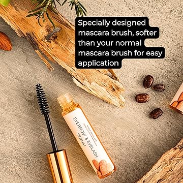 Growth serum with a specially designed brush on a wooden surface with almonds and rosemary.