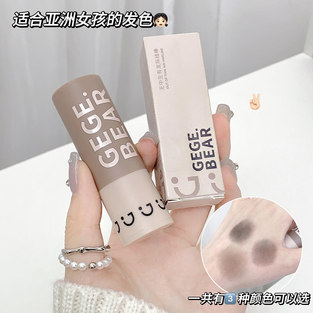 Hand holding GEGE BEAR grey hair line stamper with packaging on a light background