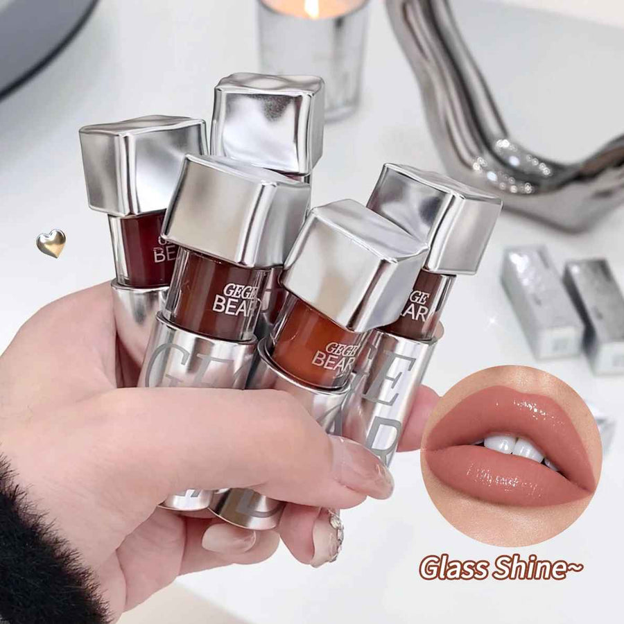 Hand holding a set of Gege Bear lip glosses with close-up of lips wearing the product.