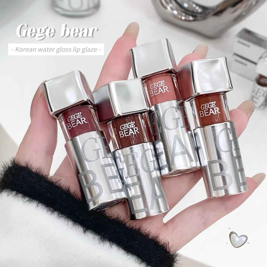 Hand holding four Gege Bear lip glosses with a white background