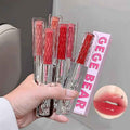 Hand holding red lip glosses with 'GEGE BEAR' packaging, close-up of lips shown.