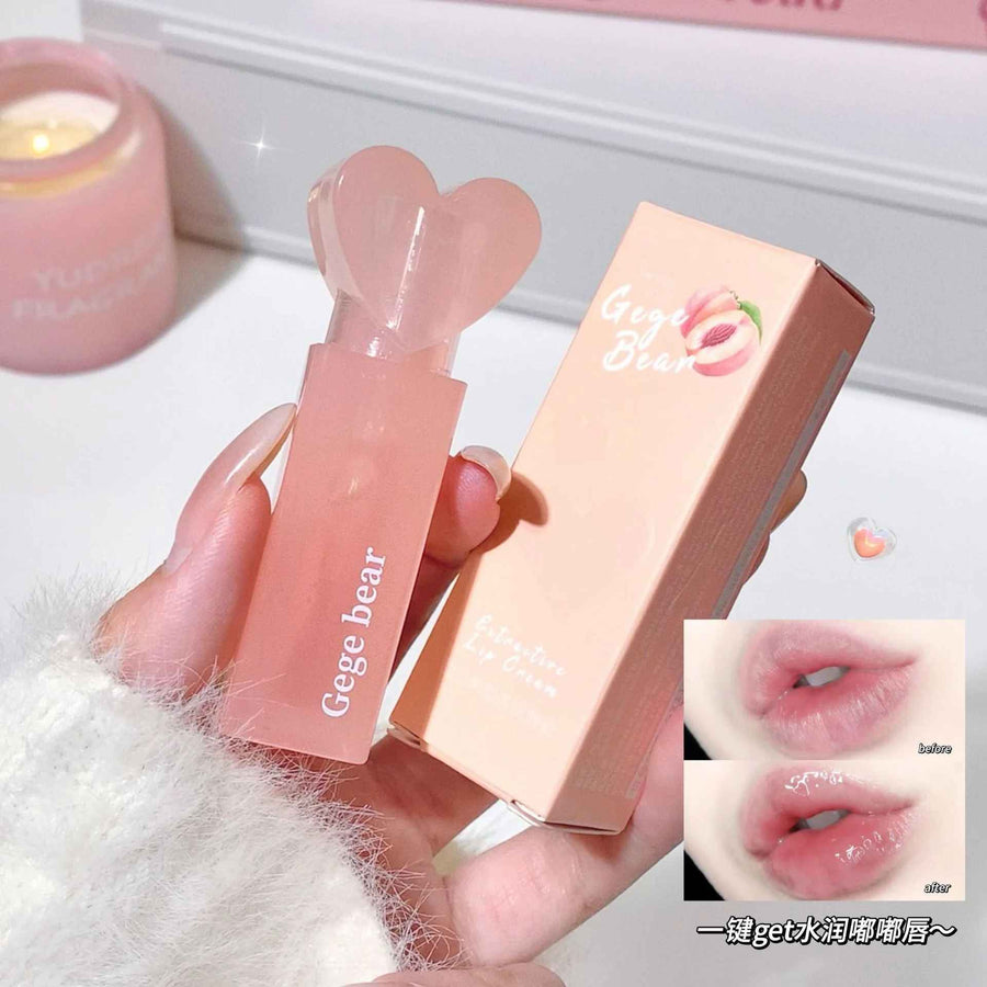 Lip balm with heart-shaped cap held by a hand, next to its packaging, on a soft surface.