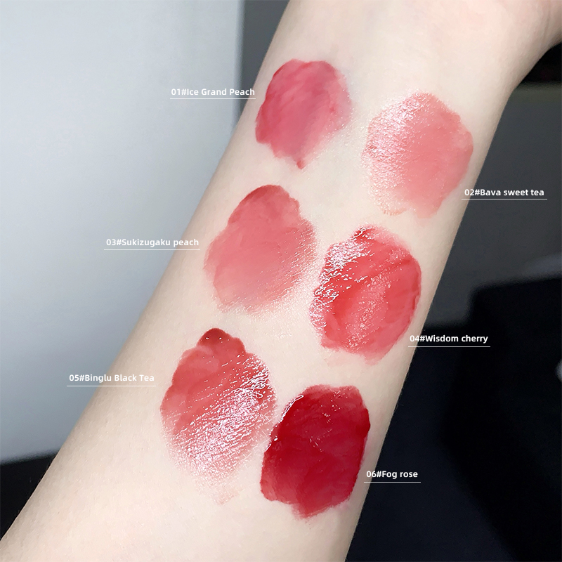 Lip gloss swatches on a person's arm with labeled colors