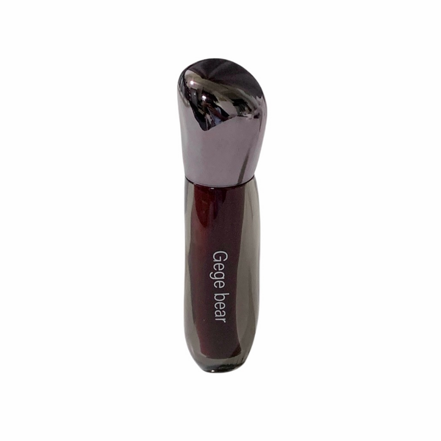 Lip gloss  with metallic cap on a white background