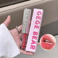 Lip gloss with pink packaging labeled 'GEGE BEAR' held by a hand, with a close-up of lips wearing the gloss.