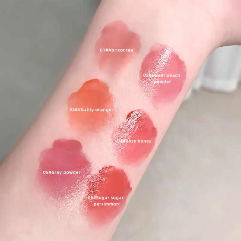 gege bear Lip gloss swatches on a person's arm with color names labeled