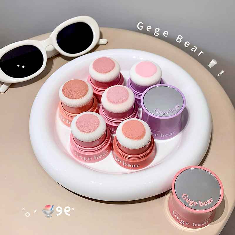 Set of pink and gray 'Gege Bear' makeup blush on a white tray with sunglasses in the background.