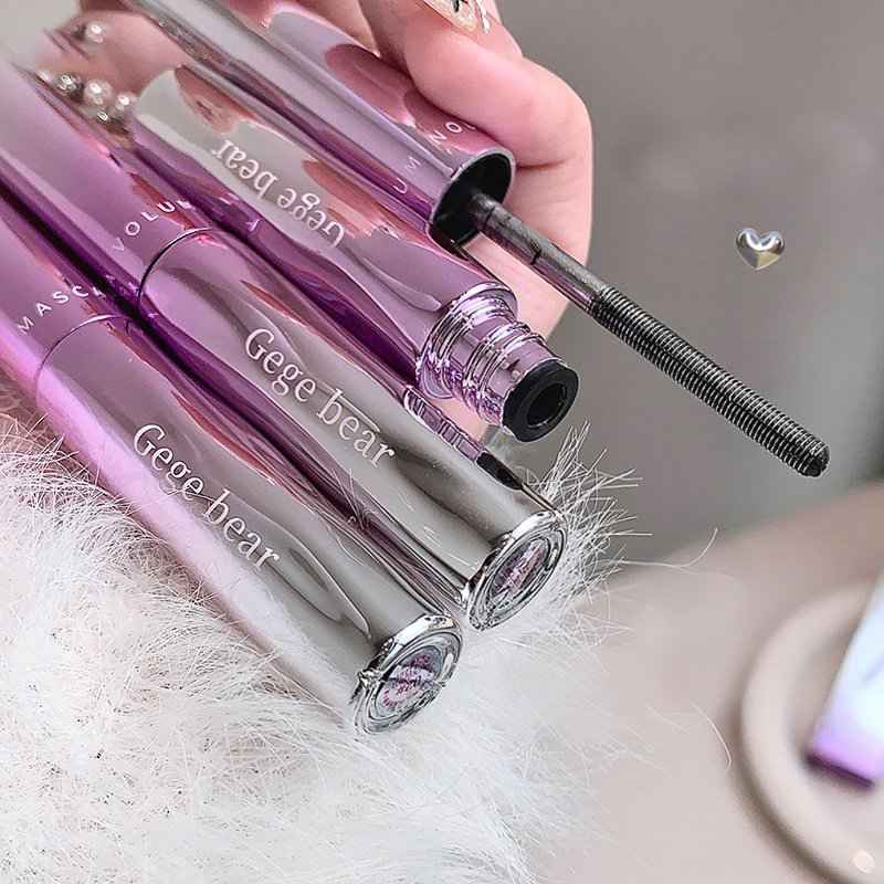 Mascara with 'Gege bear' branding held by a hand on a white surface.