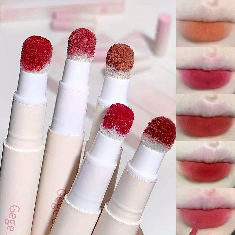 Set of lipsticks with red and brown applicators, shown on a blurred background.