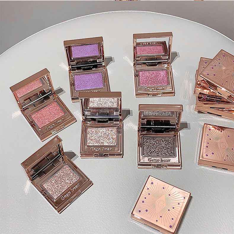 Eyeshadow palettes   with glittery shades on a white surface
