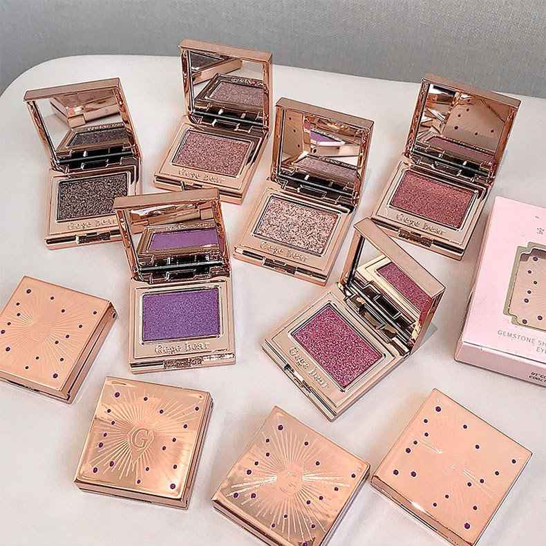 Eyeshadow palettes with rose gold cases on a white surface