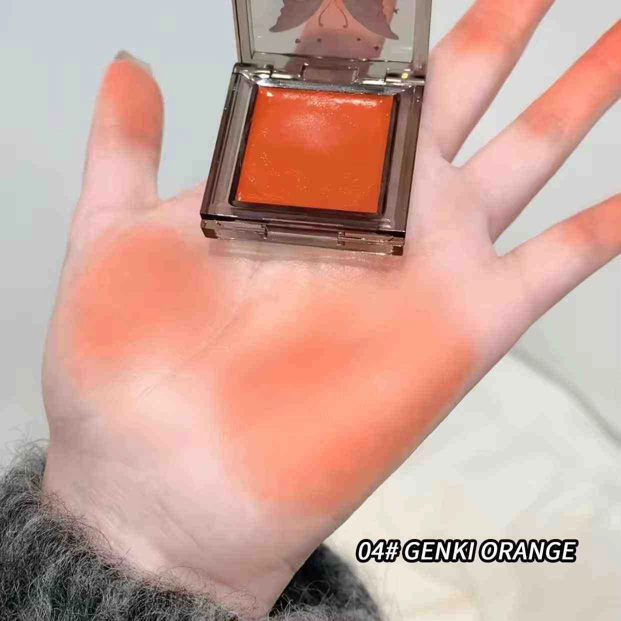 Hand holding a orange blush of Genki Orange blush with visible orange color swatch.