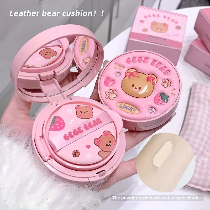 Pink Gege  bear foundation cushion with open lid showing powder inside, on a white surface.