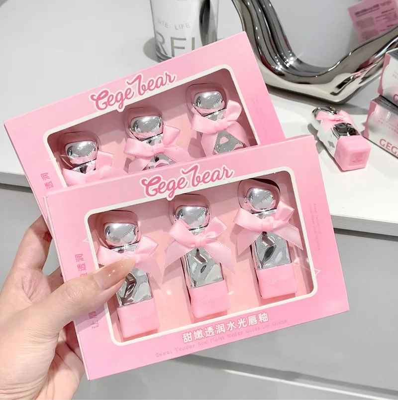 Pink 'Gege bear' lipstick packaging with silver items inside, held by a hand.