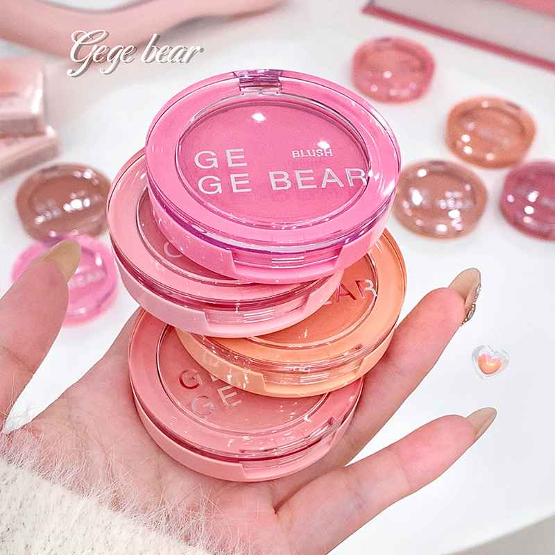 Pink blush compact with 'GEGE BEAR' branding held in a hand against a white background.