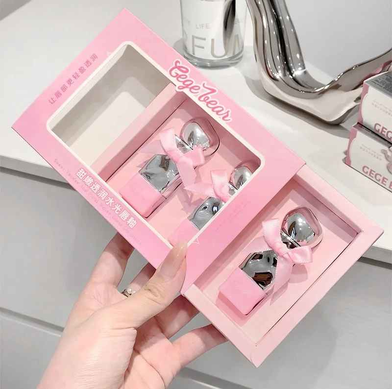 Pink box with lipsticks featuring bows held by a hand.