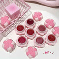 Pink lip balm containers with floral designs on a white surface.