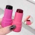 Pink lip balm stick with a black cap held by a hand on a white background