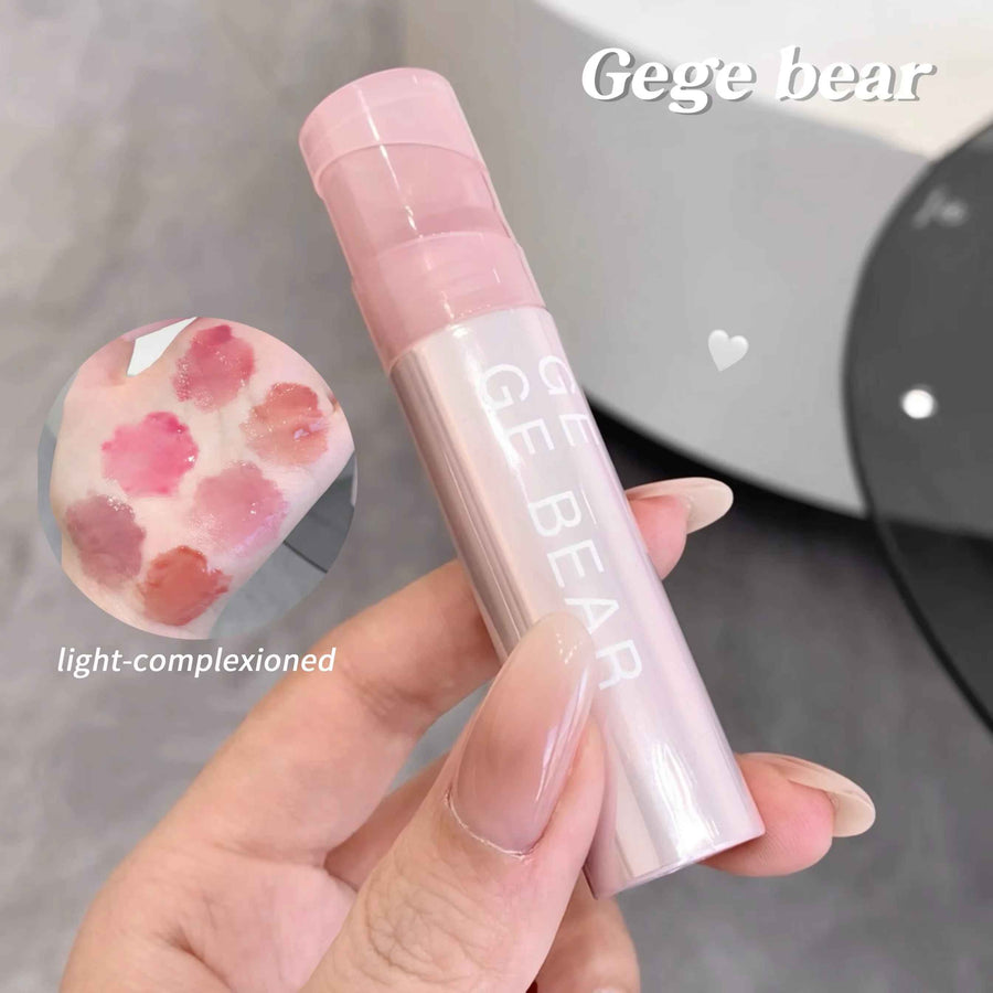 Pink lip balm with 'Gege bear' branding held by a hand, with a blurred background.
