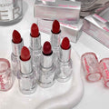 Red lip gloss with clear casings on a white surface, surrounded by 'Geege bear' boxes.