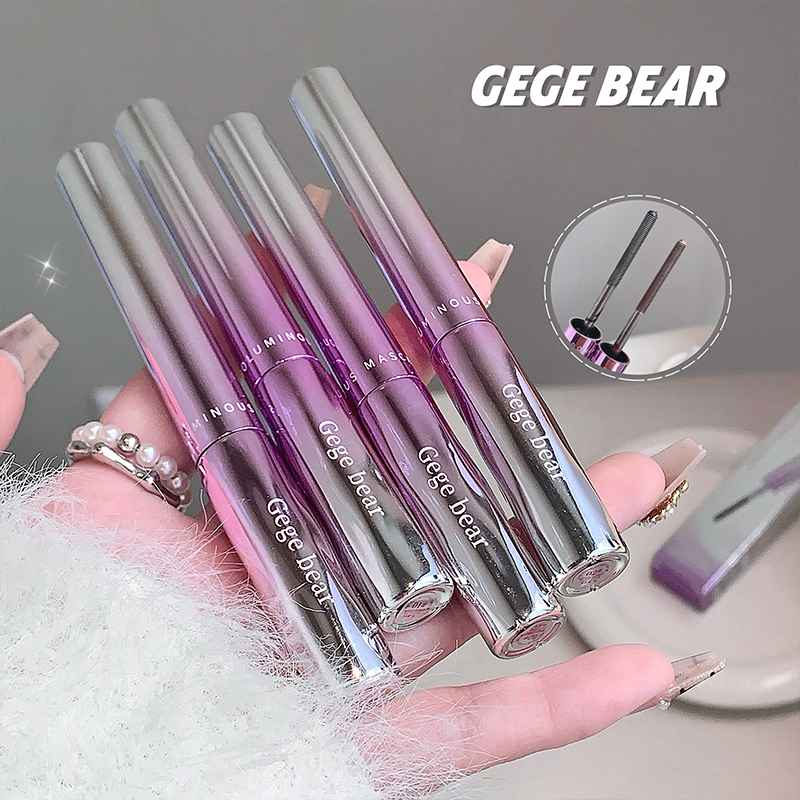 Set of GEGE BEAR mascara held in a hand with a gray background