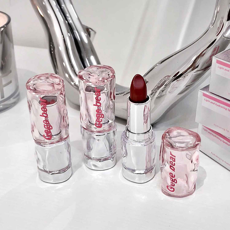 Set of lipsticks with clear casings and red lipstick on a white surface.