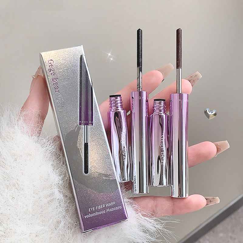 Set of makeup mascara with packaging held by a hand.