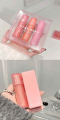Set of three pink lip glosses in a clear case held by a hand.